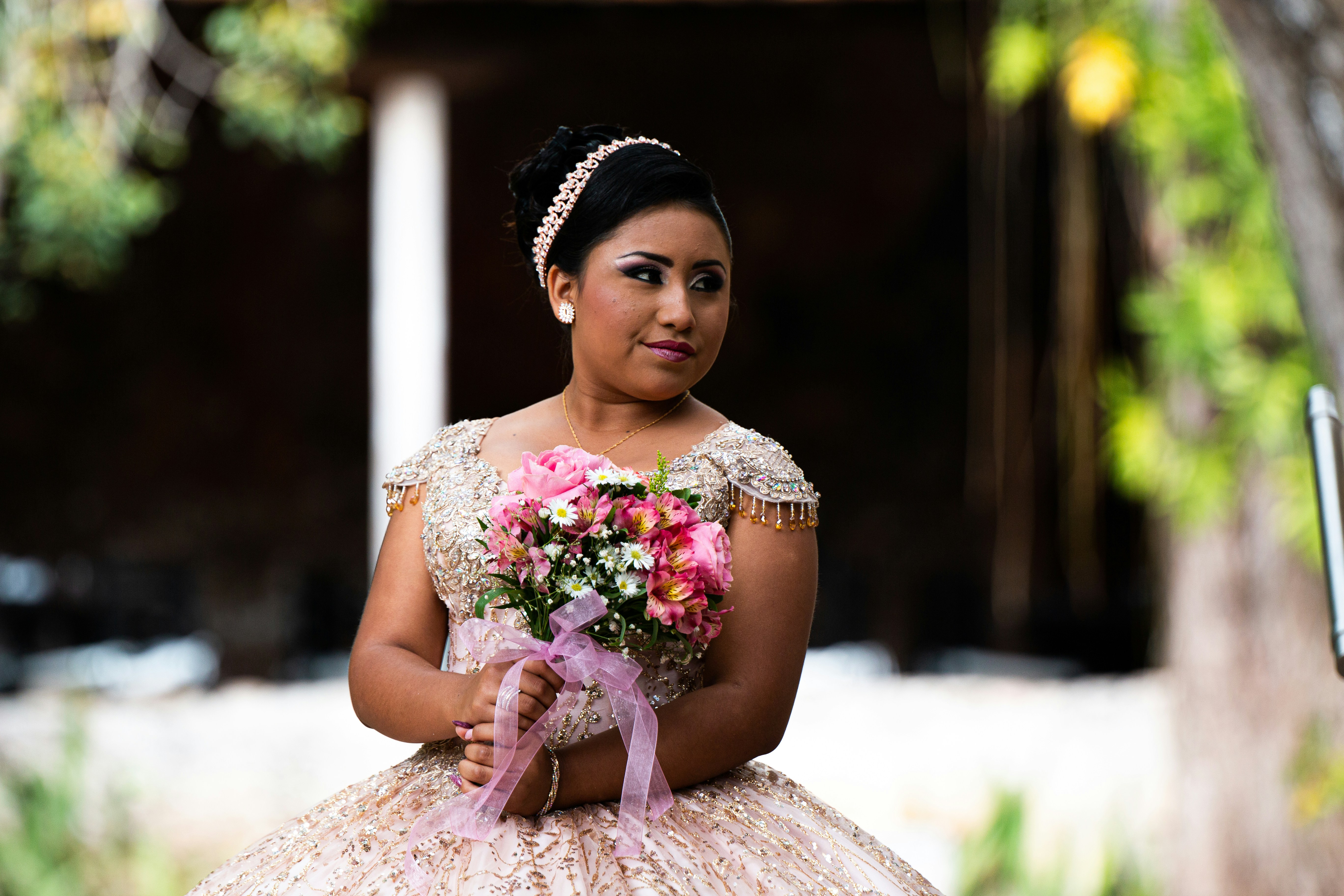 girl in pink and white floral dress holding bouquet of flowers
