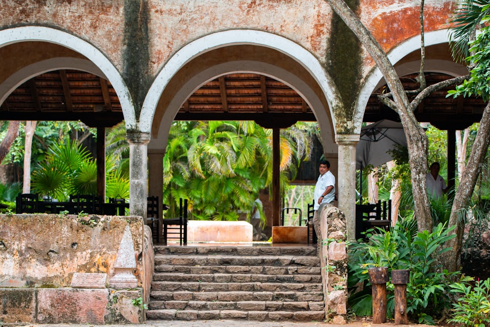 2 women standing on brown concrete arch during daytime