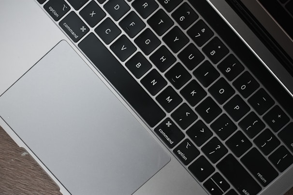 Close-up of hands replacing a laptop keyboard in a clean workspace.