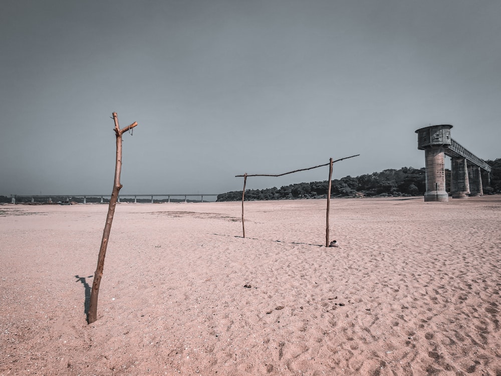 poste de madeira marrom na areia branca durante o dia