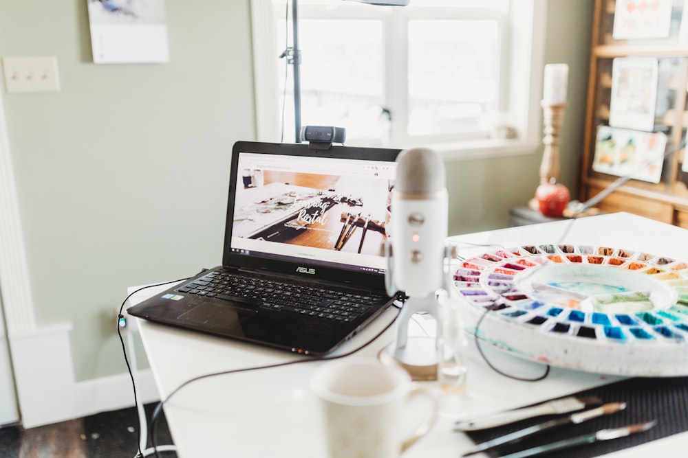 black laptop computer on white table