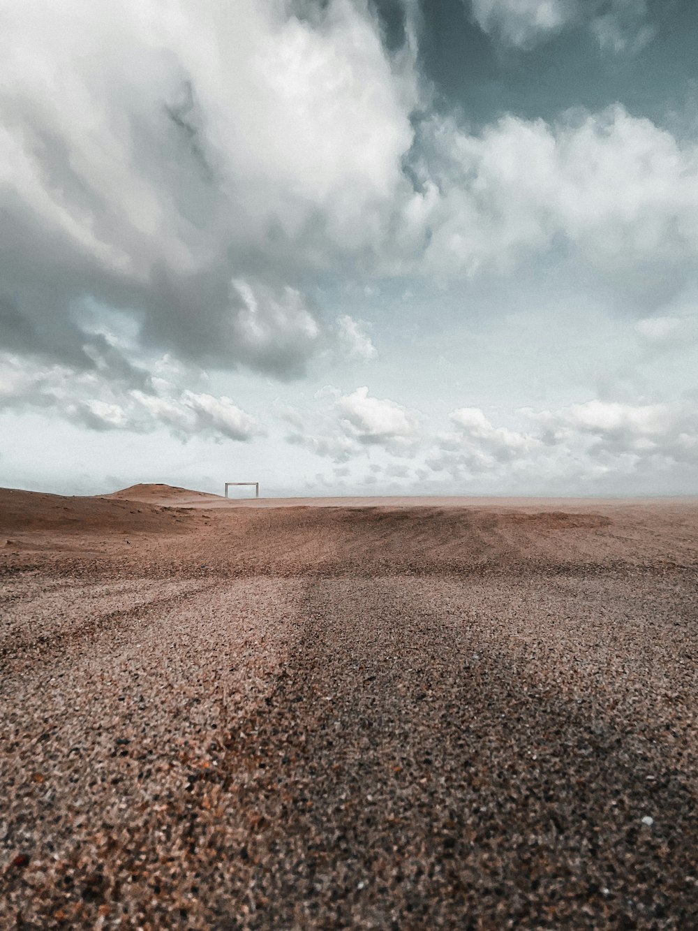 brauner Sand unter weißen Wolken und blauem Himmel tagsüber