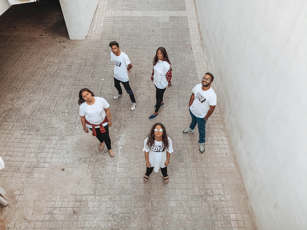 group of people in white shirt and black pants standing on gray concrete floor
