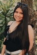 woman in black tank top standing beside green plant