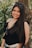 woman in black tank top standing beside green plant