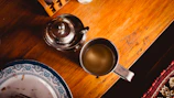 An inviting wooden table topped with an assortment of fresh pastries and a ceramic mug of tea.
