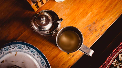 An inviting wooden table topped with an assortment of fresh pastries and a ceramic mug of tea.