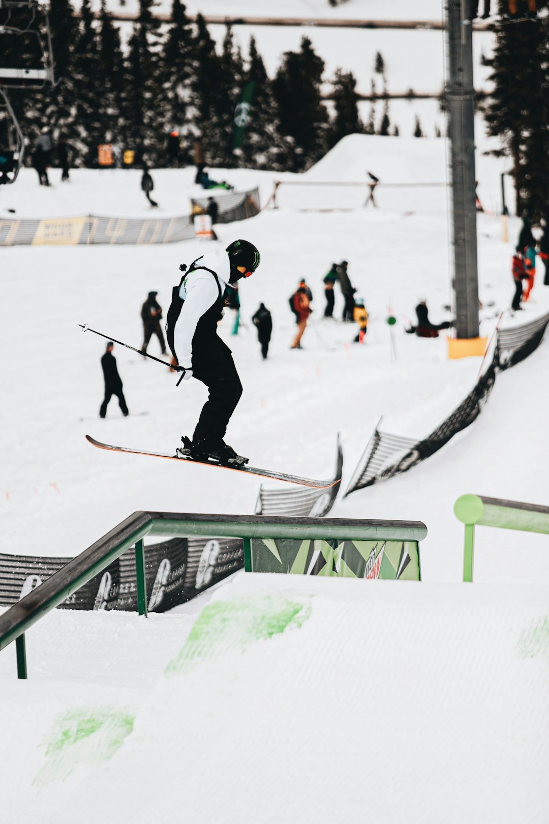 man in black jacket and black pants riding on black and white snowboard during daytime
