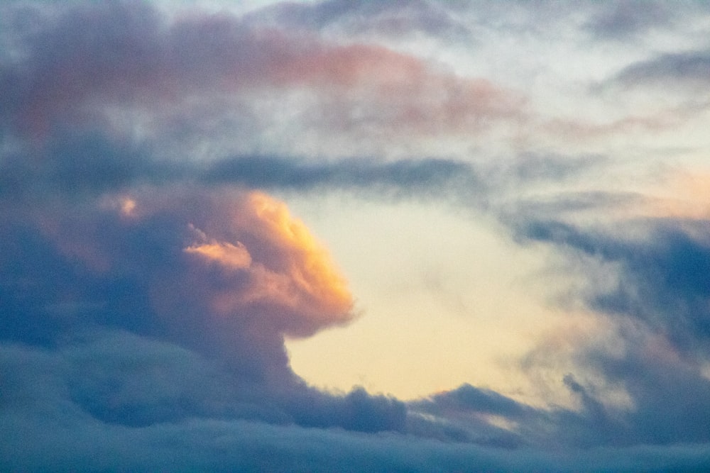 white clouds over mountain during daytime