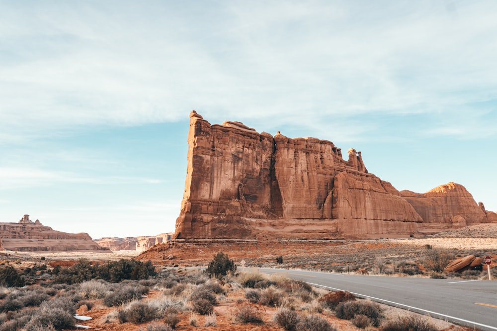 brown rock formation under white clouds during daytime