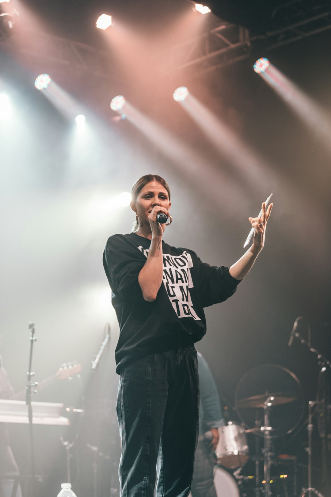 man in black and white crew neck t-shirt singing on stage