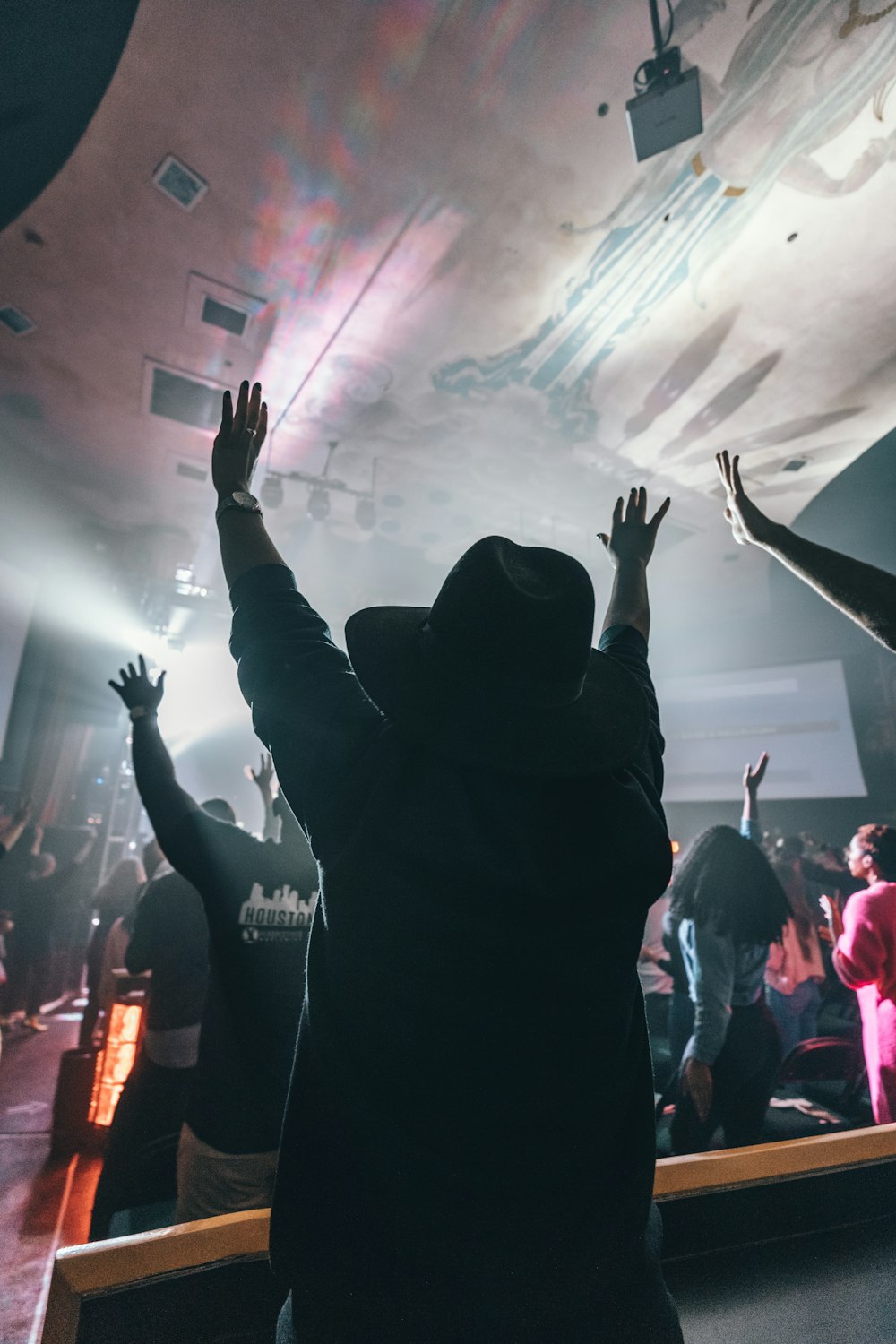 people raising hands up in front of stage