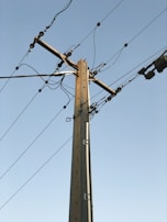 brown electric post under blue sky during daytime