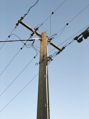 brown electric post under blue sky during daytime