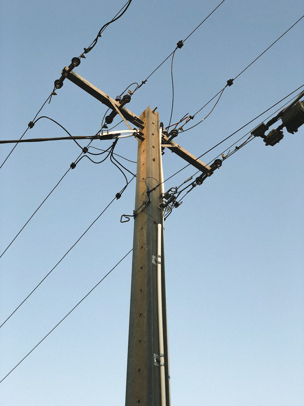 palo elettrico marrone sotto il cielo blu durante il giorno