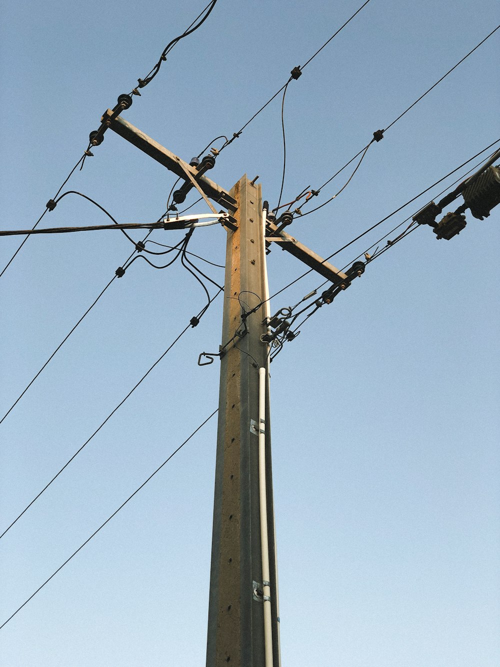 brown electric post under blue sky during daytime