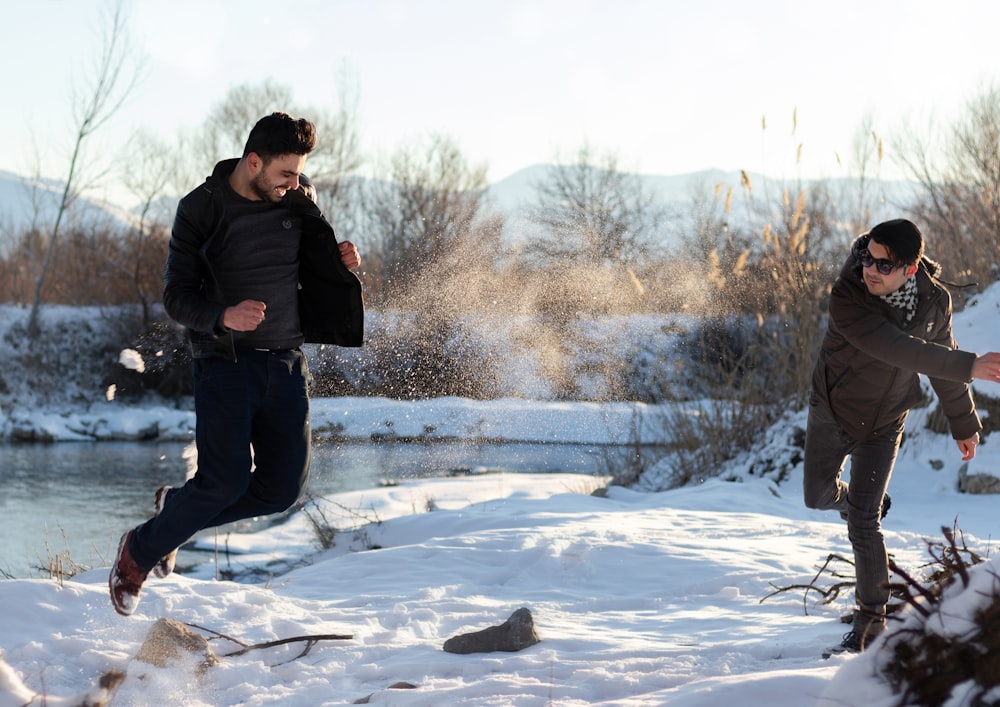 man in black jacket standing on snow covered ground during daytime