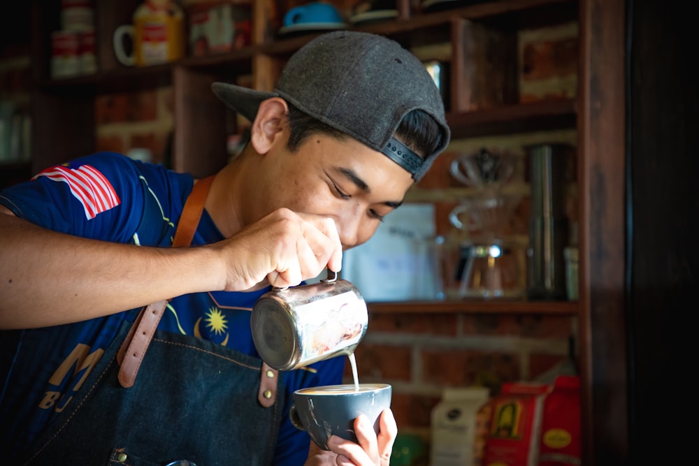 man in blue and black shirt holding white ceramic bowl