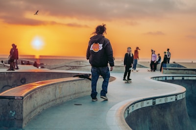 A dramatic sunset over a skatepark filled with riders.
