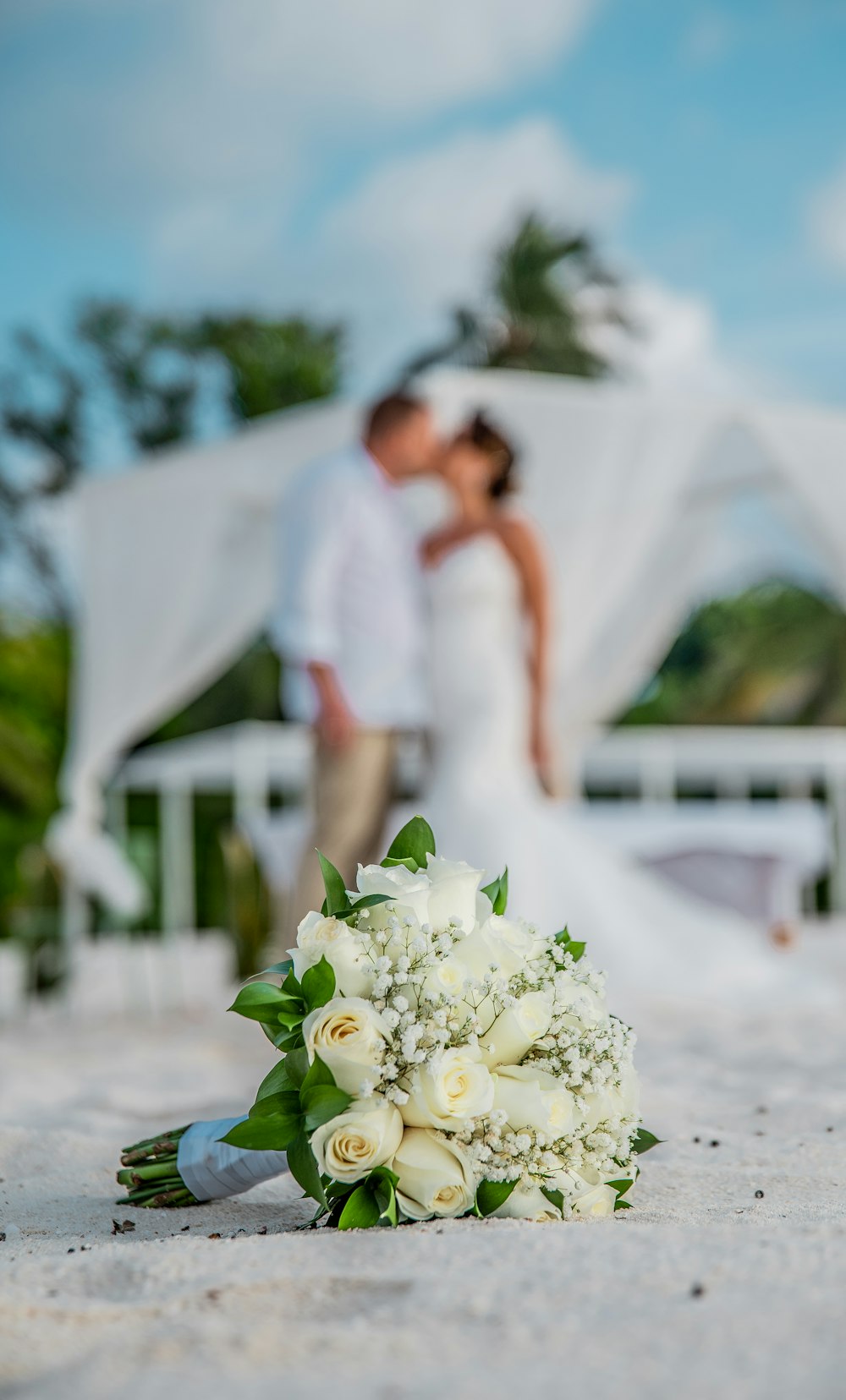 man in white dress shirt holding white flower bouquet