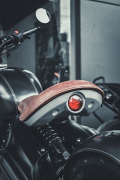 Top view of a white motorcycle seat with red stitching details.