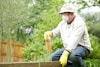 man in white long sleeve shirt and blue denim jeans sitting on brown wooden fence during