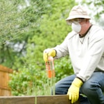 man in white long sleeve shirt and blue denim jeans sitting on brown wooden fence during