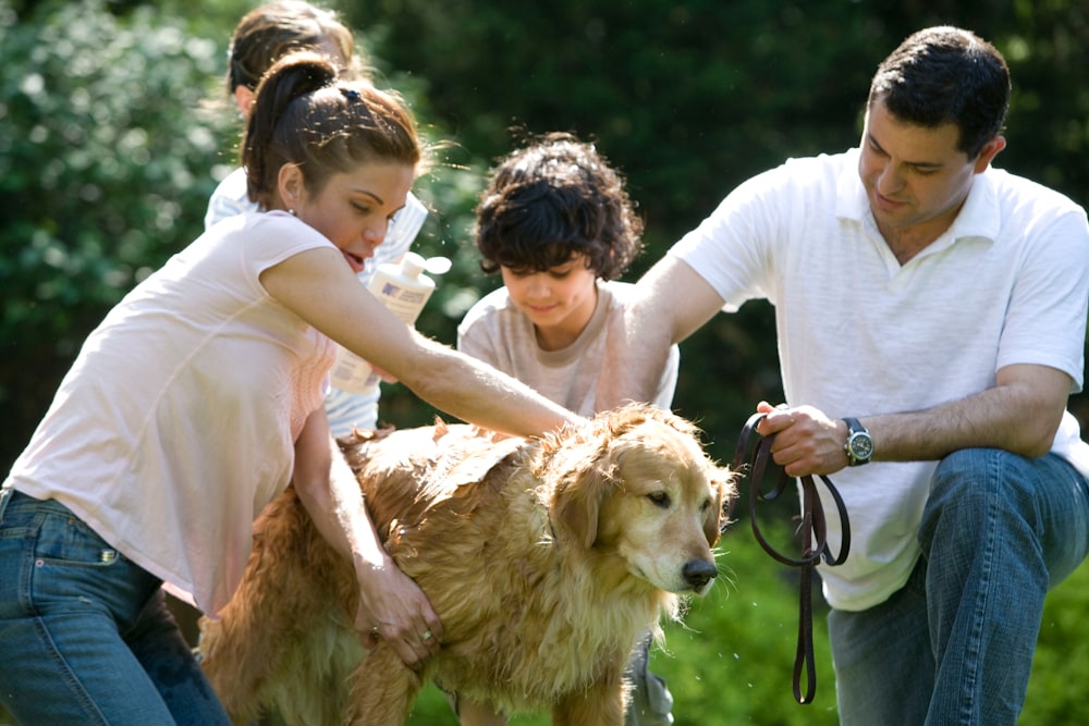 woman in white shirt holding brown short coated dog