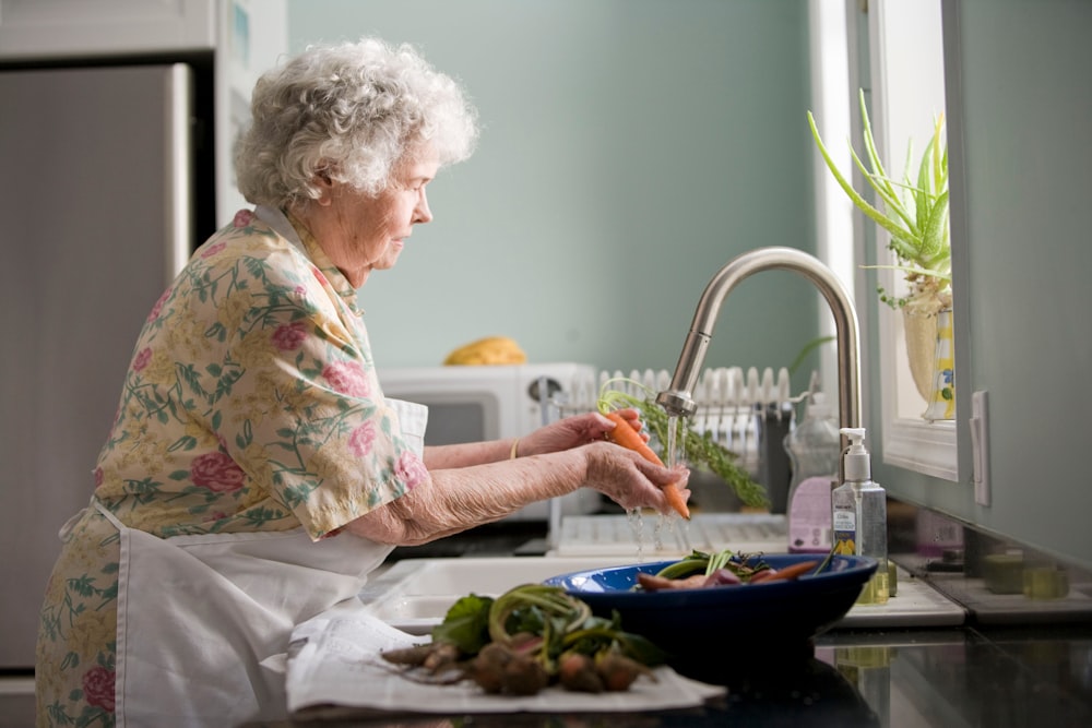 woman in purple and white floral shirt sitting on white bed