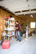 A cluttered garage being organized and cleaned out.