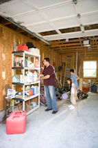 A friendly professional from Refined Garage discussing renovation plans with a homeowner in a bright, organized garage space.