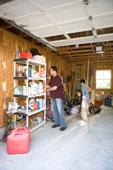 A clean, well-organized garage with shelves neatly arranged and open floor space gleaming with sunlight.