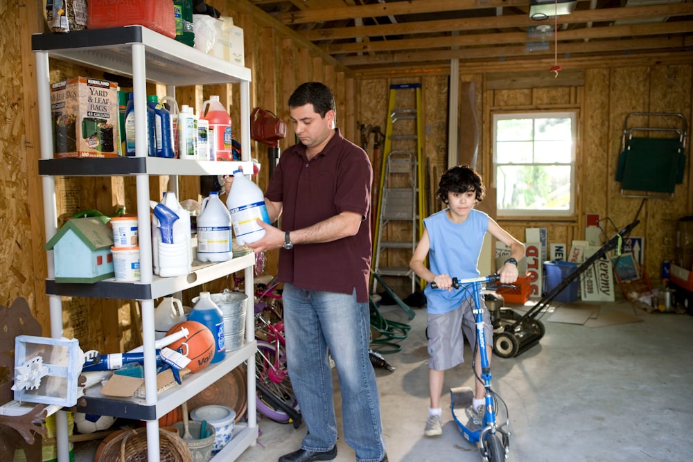 man in brown polo shirt and blue denim jeans standing beside man in blue denim jeans