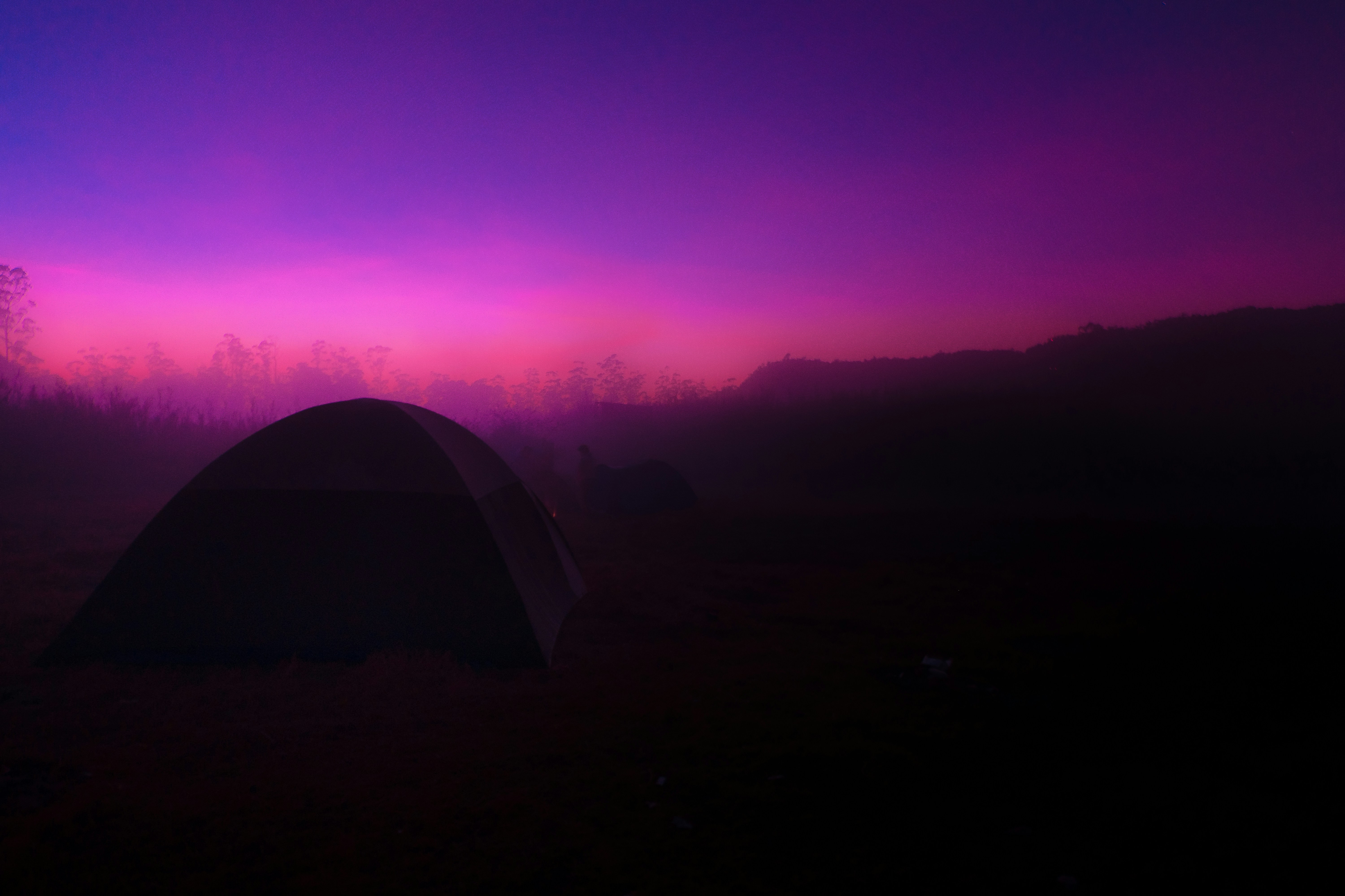 tent on green grass field during sunset