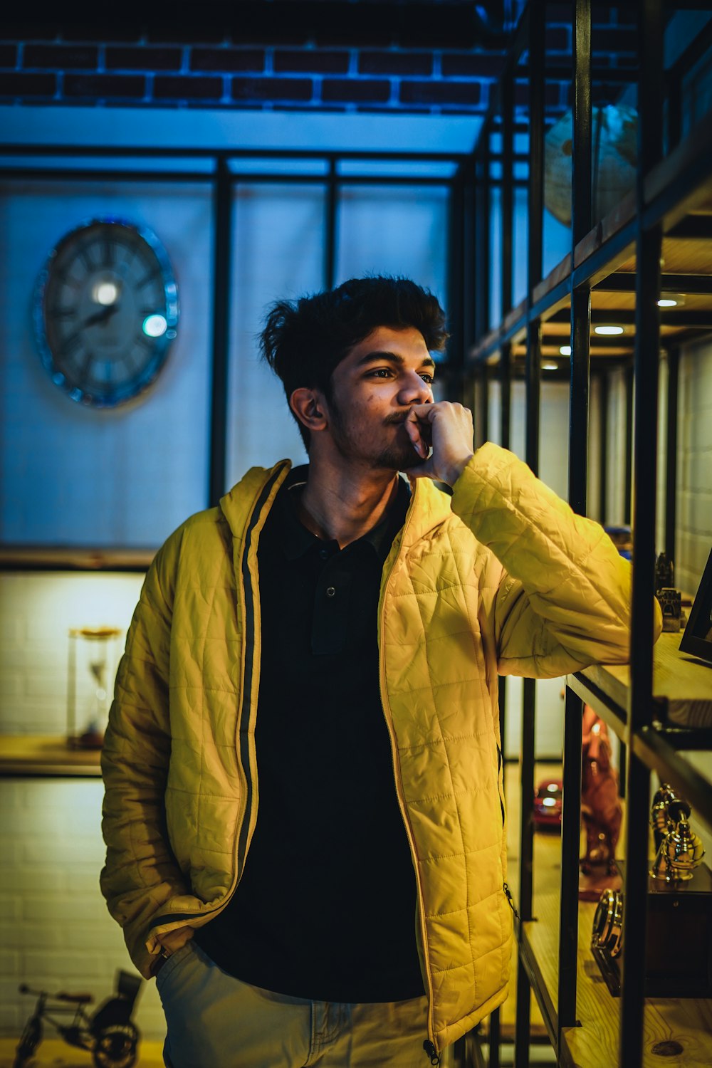 man in yellow jacket standing near glass window