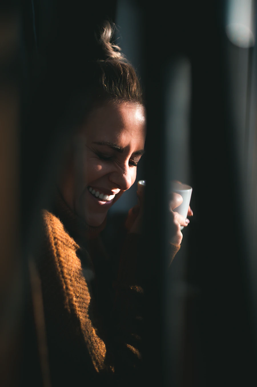 Dueña de negocio sonriendo con una taza de café, luz cálida