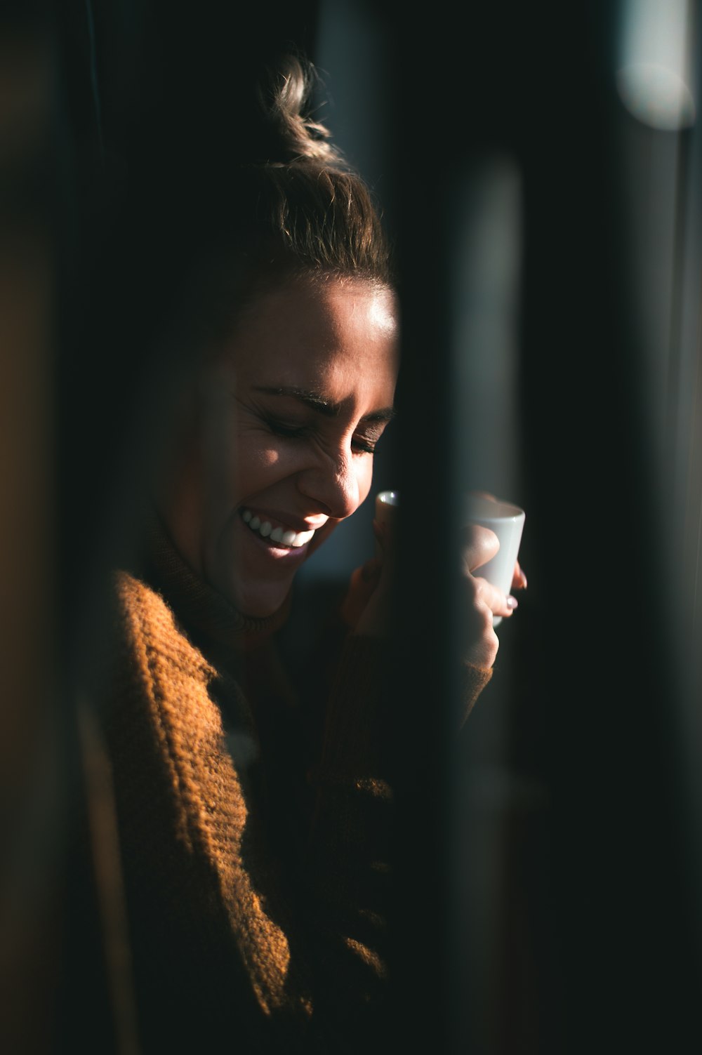 smiling woman holding white ceramic mug