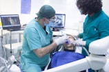 man in teal scrub suit holding baby