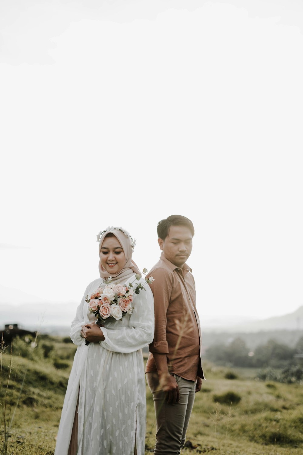 man in brown jacket holding girl in white dress