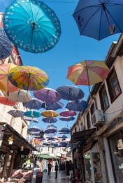 assorted umbrellas hanging on wire during daytime