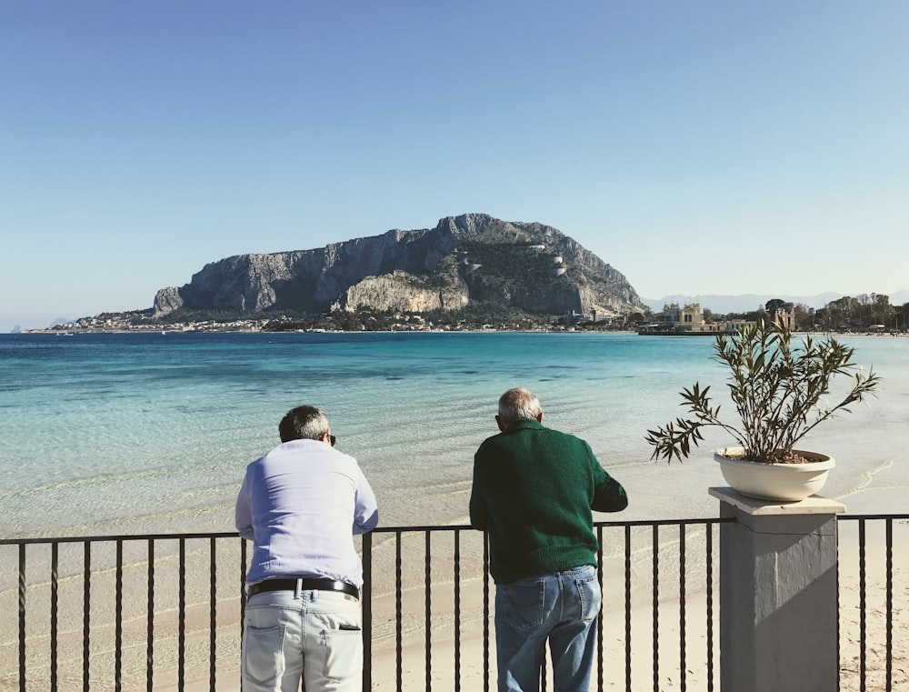 man in white shirt standing near body of water during daytime