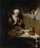A Christian family holding hands in prayer around the dinner table in soft morning light.