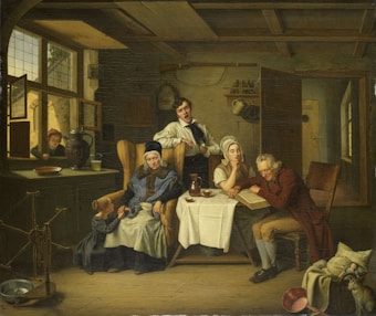 In a rustic, dimly lit interior, a family gathers around a table. An elderly woman, wearing a bonnet, sits in an armchair while a young child stands by her side. A weary elderly man, dressed in a red coat, leans over a large book, apparently sleeping or deep in thought. A woman, possibly in middle age, sits with her chin resting on her hand, appearing contemplative. Nearby, a young man is yawning or singing, leaning against the back of a chair. Through an open window, a girl is peering inside, holding a letter. The room contains domestic objects such as a spinning wheel, a jug, and other household items.