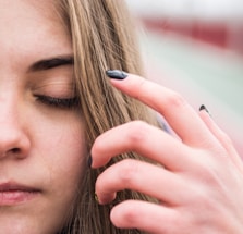 A close-up of a person gently touching their scalp, highlighting healthy hair growth.