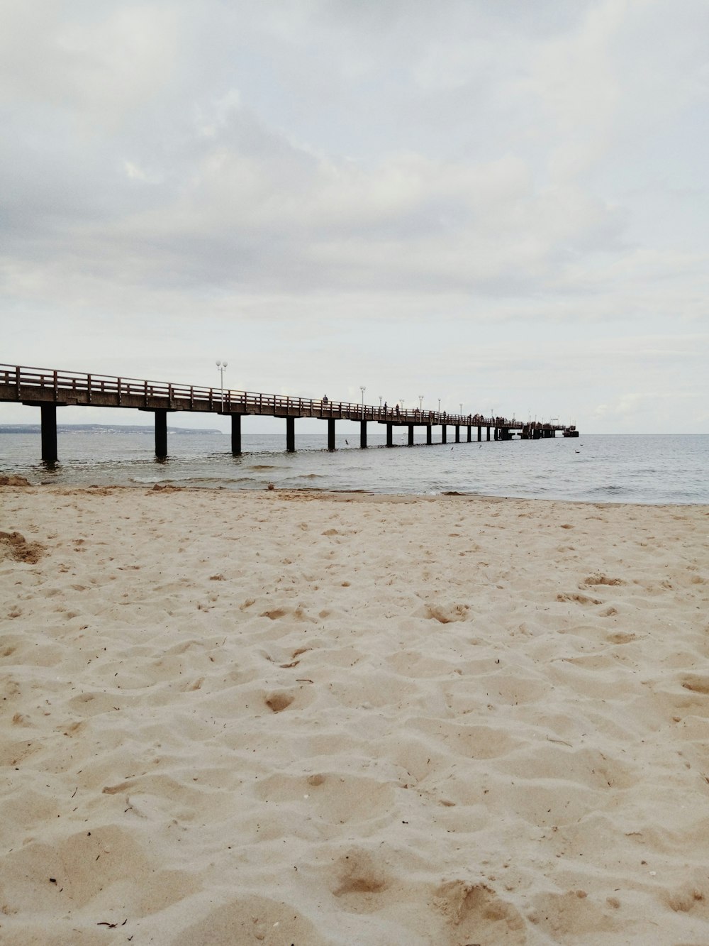 brown wooden dock on sea under white clouds during daytime