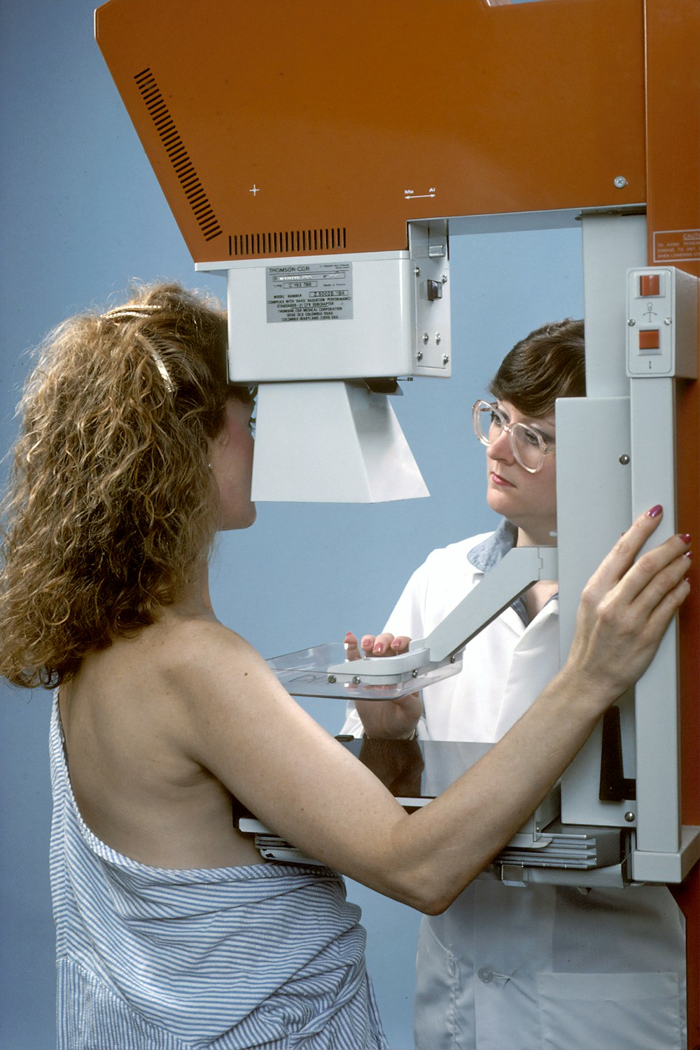 woman in white tube top holding white printer paper