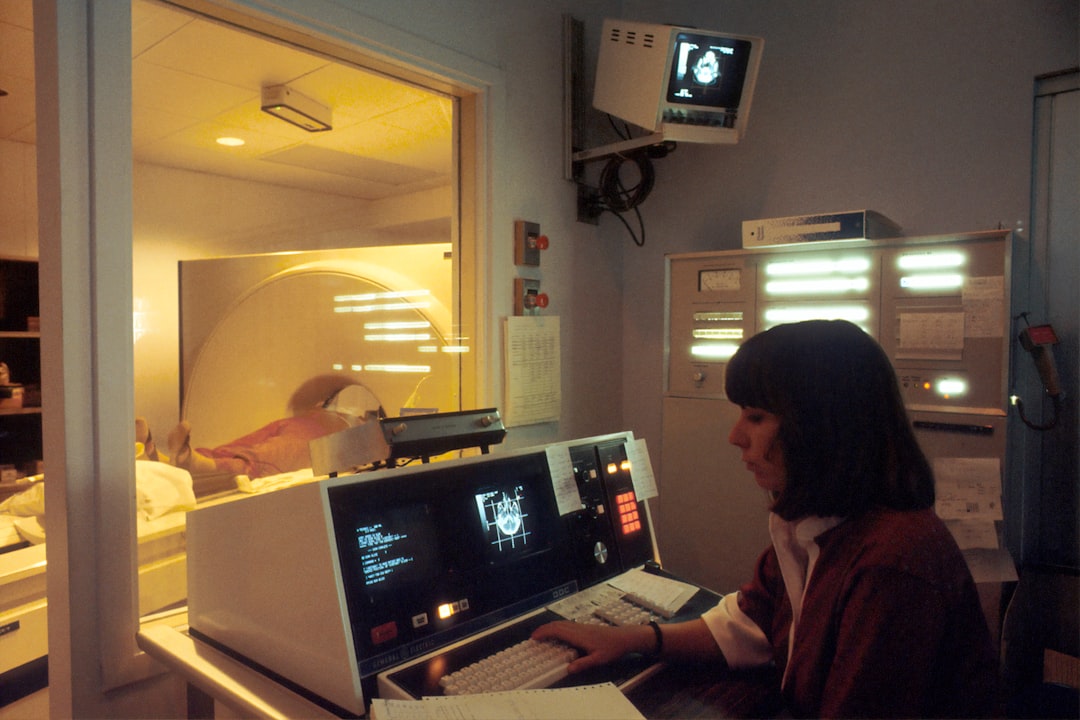 woman in red shirt sitting in front of computer - Asbestos Abatement