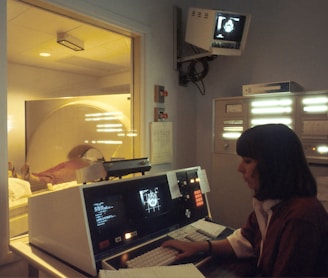 woman in red shirt sitting in front of computer