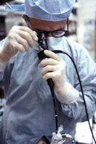man in blue dress shirt holding black corded device