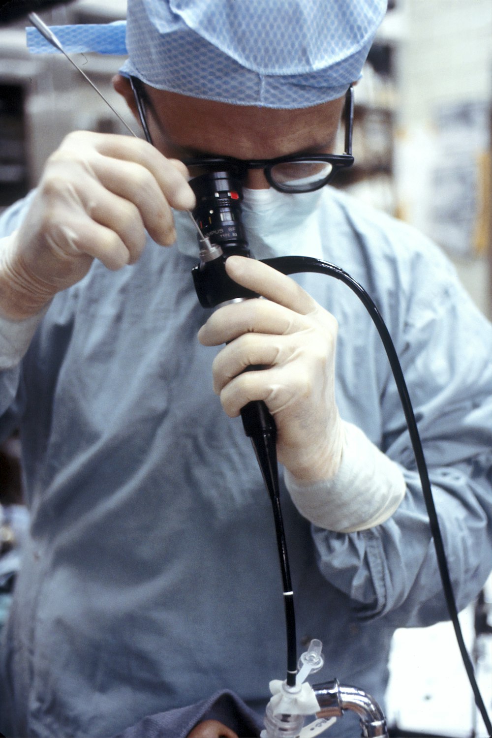 man in blue dress shirt holding black corded device